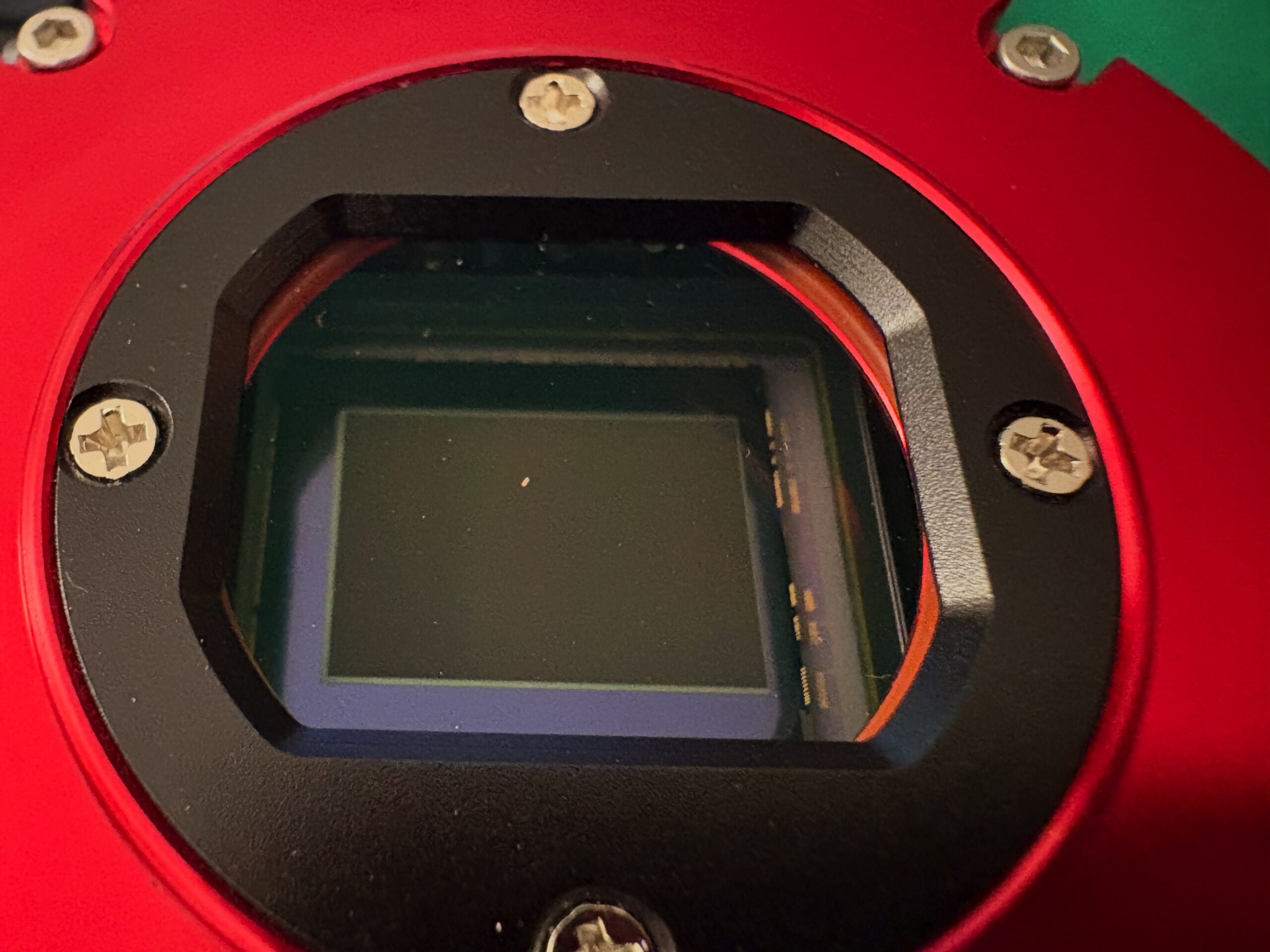 La finestra di protezione della camera ZWO ASI294MC Pro contaminata da numerosi granelli di polvere e da un frammento di erba tagliata.